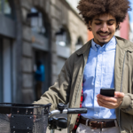 Mann mit Fahrrad kauft etwas auf seinem Smartphone